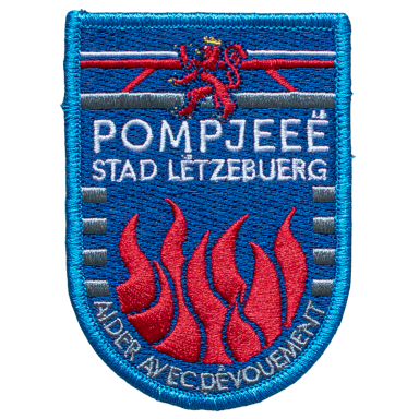 Wappen der Feuerwehr Pompiéen aus Luxemburg mit roten Flammen und Löwenmotiv.