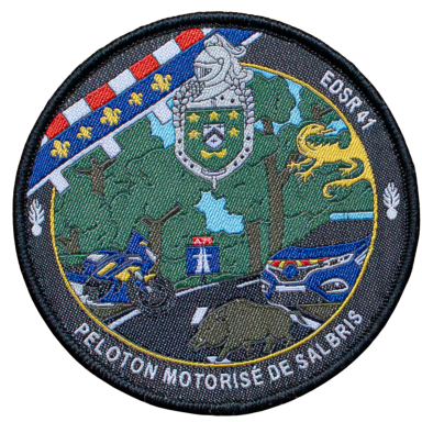 Abzeichen mit Motorrädern, Schild und einer Straße, umgeben von Bäumen und Wappen.