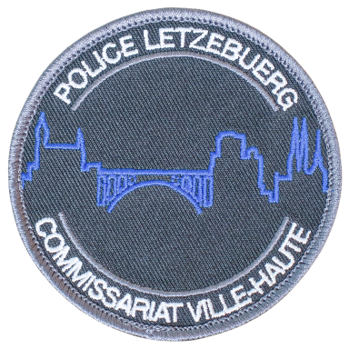 Abzeichen der Polizei Luxemburg mit stilisierter Skyline und Brücke.
