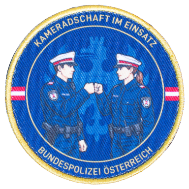 Bundespolizei - Kameradschaft im Einsatz Abzeichen der Bundespolizei Österreich mit zwei Polizisten in Uniform beim Fist Bump.