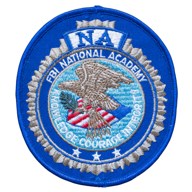 Emblem der FBI National Academy mit Adler und amerikanischer Flagge.