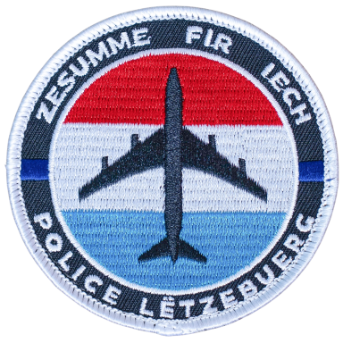 Abzeichen der luxemburgischen Polizei mit Flugzeugmotiv und nationalen Farben.
