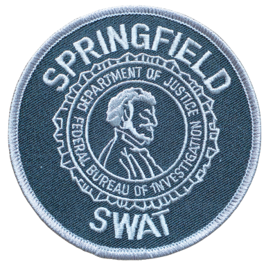 Abzeichen mit dem Schriftzug "Springfield SWAT" und einem Porträt von Abraham Lincoln.