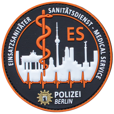 Rundes Abzeichen mit stilisiertem Stadthorizont von Berlin und medizinischen Symbolen.